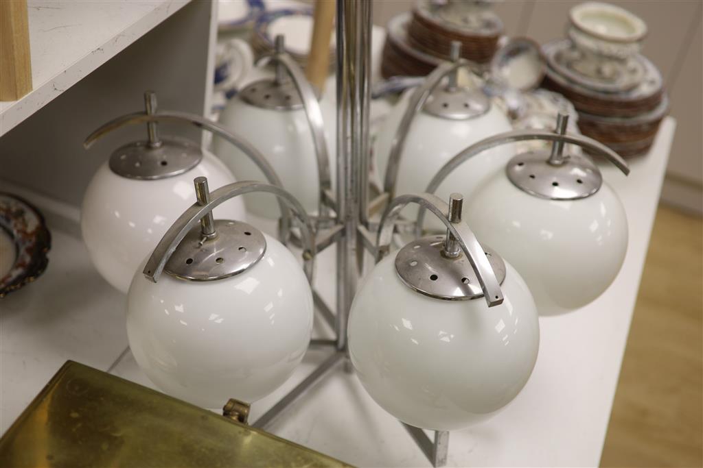 An Art Deco chrome six branch electrolier with white glass shades